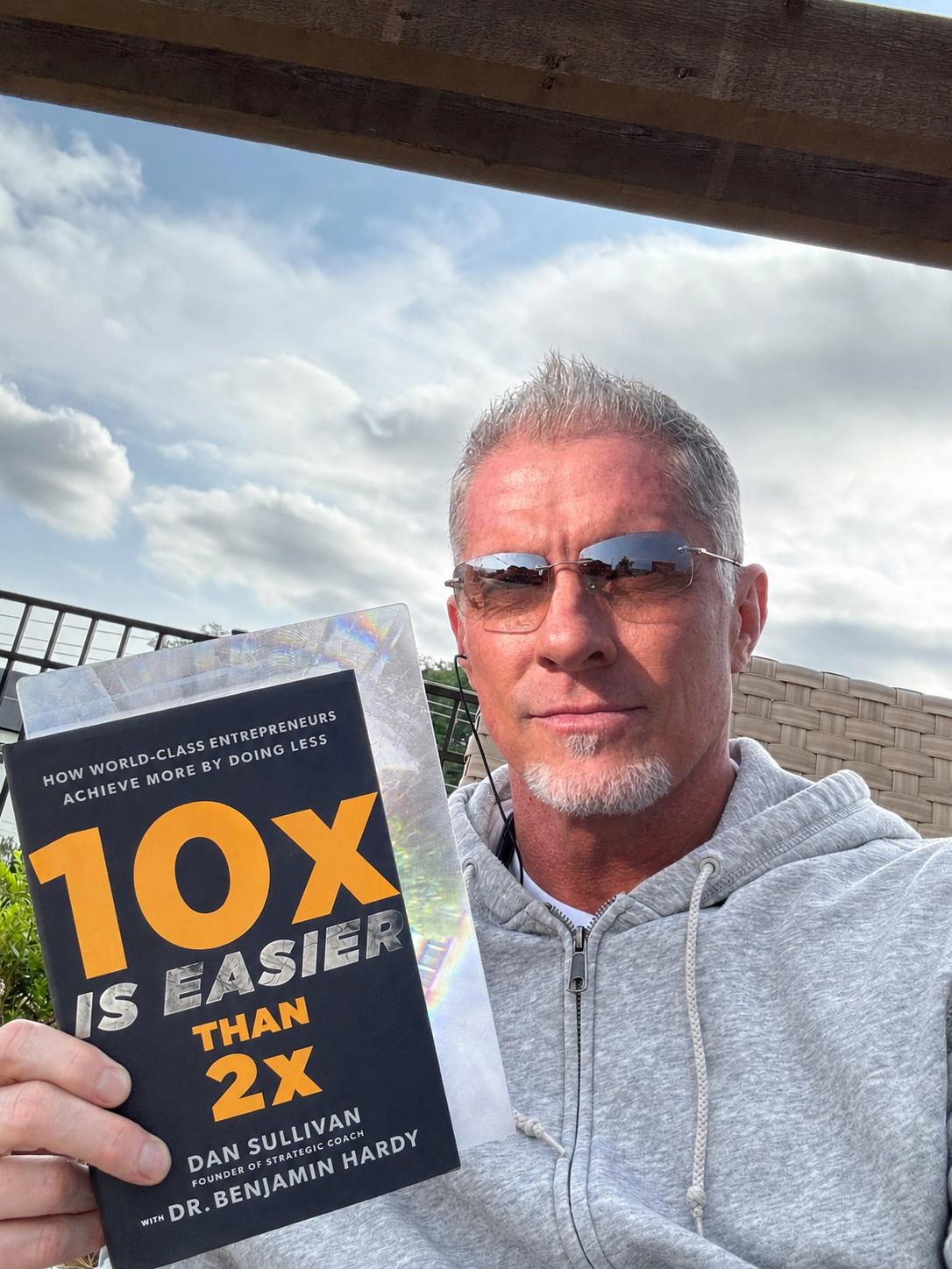 Shawn Greenway outside on an overcast afternoon, holding a book